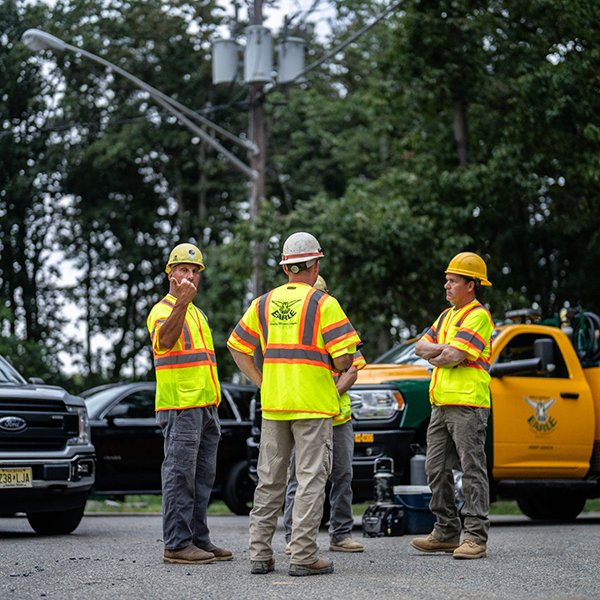 Earle employees discuss construction logistics beside a truck in NJ.