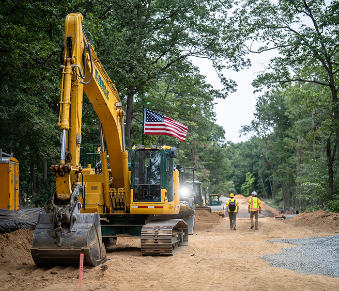 An Earle excavator sits idle with two construction workers in New Jersey.