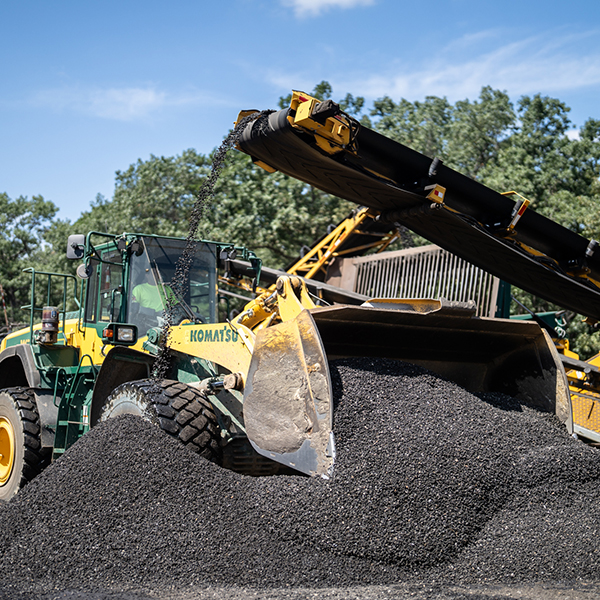 A bulldozer pushes asphalt aggregate materials in NJ.
