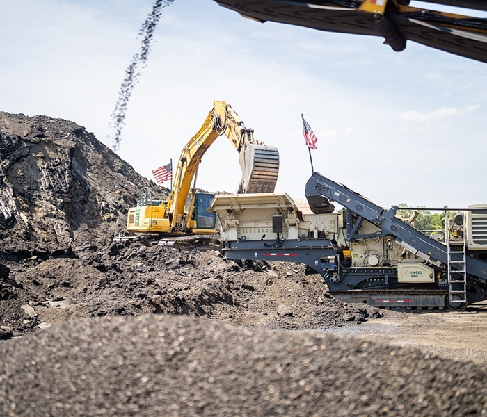 An excavator digs into dirt materials on an Earle heavy civil site in New Jersey.