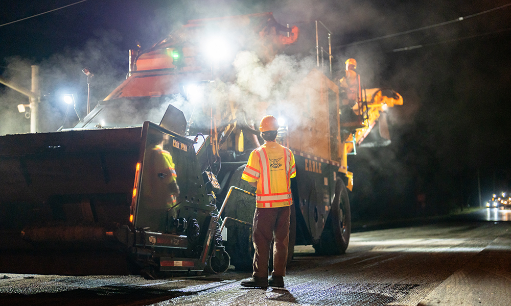 Earle employees servicing a construction site with an asphalt trailer. NJ.