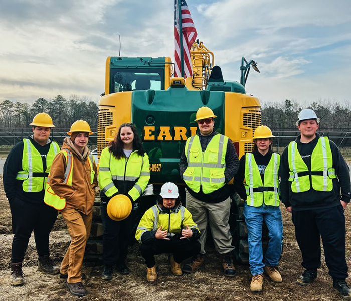 Earle Family Foundation group post beside heavy civil equipment in New Jersey.